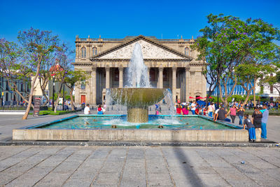 Fountain in park against blue sky