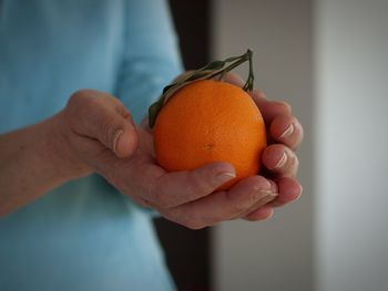 Cropped image of hand holding orange