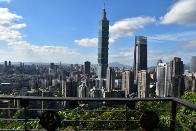 View of buildings in city against cloudy sky