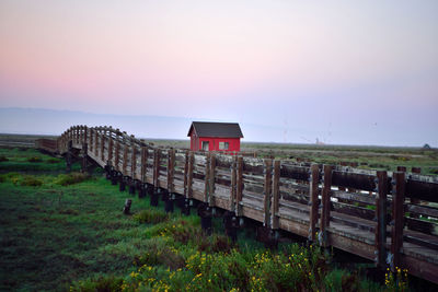 Lifeguard hut on field against sky during sunset