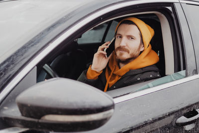 Millennial man drive the car and calling by smartphone. high quality photo