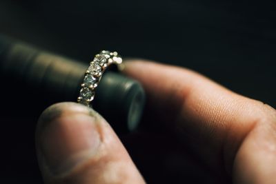 Close-up of hand making ring over black background