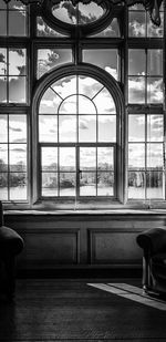 Empty chairs and tables in glass window