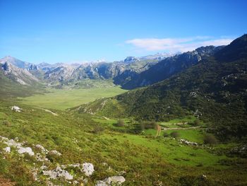 Scenic view of landscape and mountains against blue sky