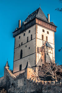 Low angle view of old building against clear blue sky