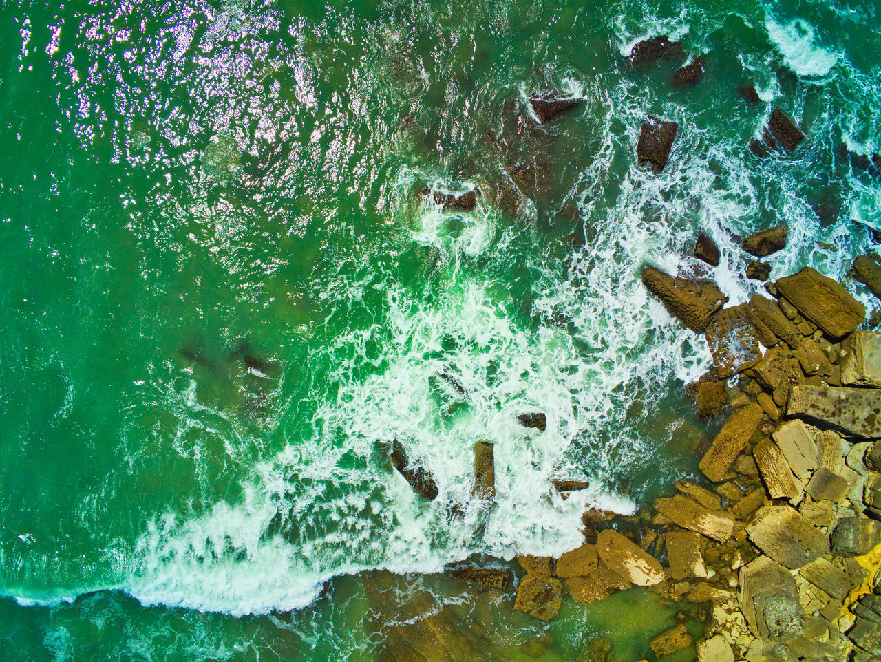 CLOSE-UP OF ROCKS BY SEA