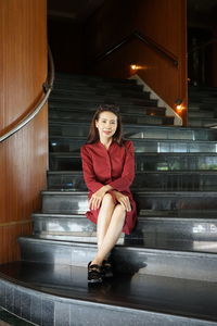 Portrait of smiling mature woman sitting on staircase