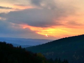 Scenic view of silhouette mountains against sky at sunset