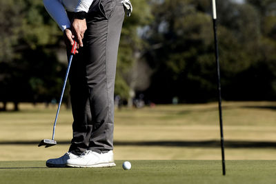 Low section of man walking on field