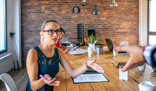 Offended woman arguing with colleague for problems in coworking