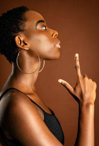 Close-up portrait of young woman holding mobile phone