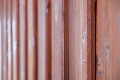 Brown boards of a vertical wood panelling as texture with a course from sharp to blurred