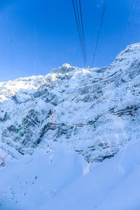 Snow covered mountain against blue sky