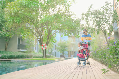 Rear view of girl with umbrella against trees