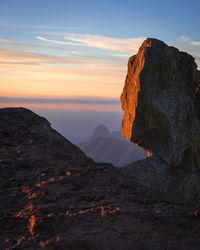 Rock formation on land against sky during sunset