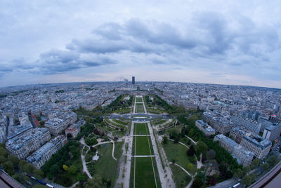 Aerial view of cityscape against cloudy sky