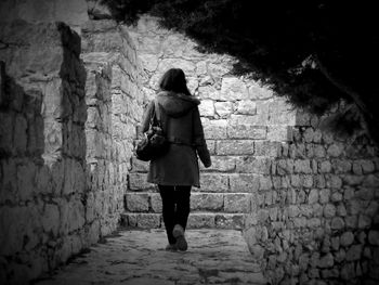 Rear view of woman walking at old ruin castle