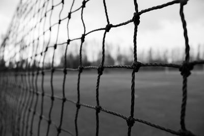 Close-up of barbed wire fence against sky