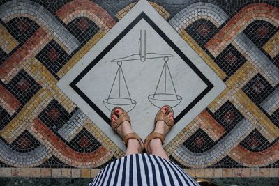 Low section of woman standing on tiled floor