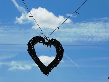 Close-up of heart shape against blue sky