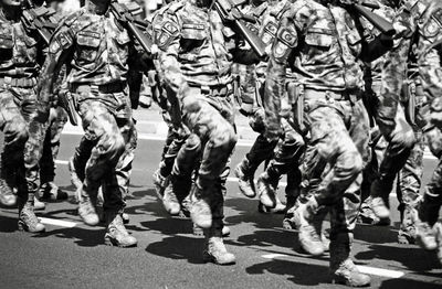 Soldiers marching on street in city