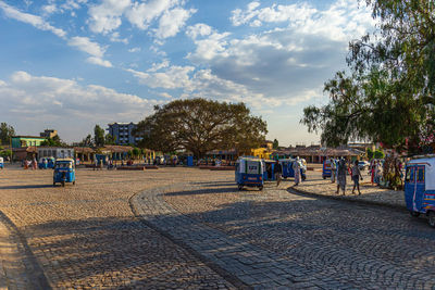 People on street in city against sky