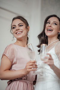 Portrait of a smiling young woman drinking glass