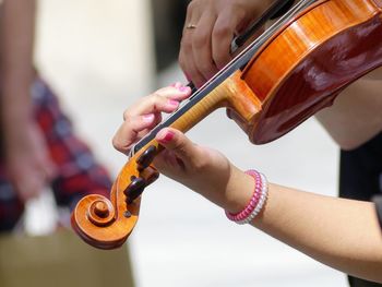 Cropped hands of woman playing violin