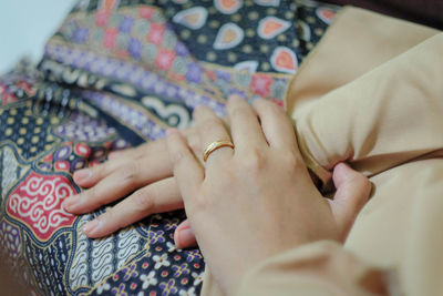 Midsection of woman sitting with hands clasped