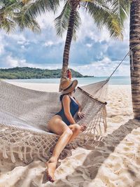 Full length of young woman relaxing on beach