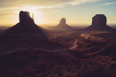 Rock formations on landscape against sky during sunset