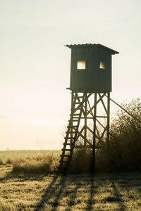Low angle view of water tower against sky during sunset