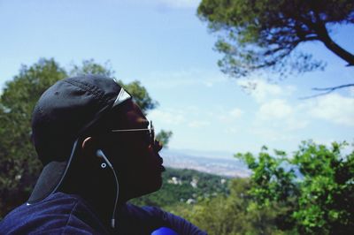 Side view of man wearing sunglasses against sky