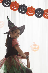 Smiling boy standing against wall during halloween