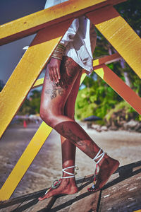 Low section of woman with leg tattoo walking down lifeguard tower.