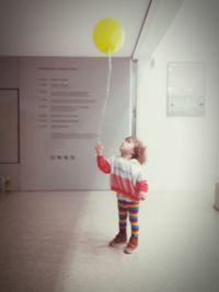 Rear view of girl playing with ball at home