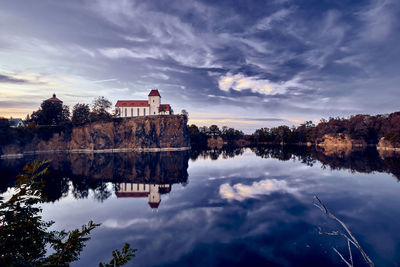 Reflection of building on lake against sky