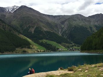 Scenic view of lake by mountains against sky