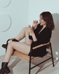 Young woman sitting on chair at home