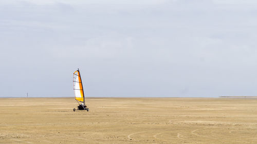 Sailboat on beach against sky