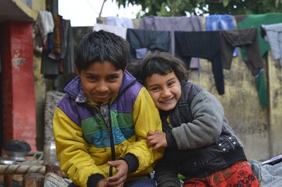 Portrait of smiling siblings sitting outdoors