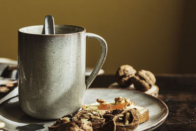 Delicious breakfast with coffee, toast and walnuts on plate in morning