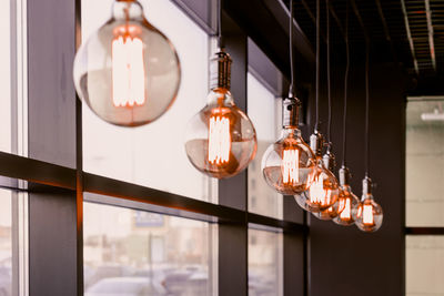 Illuminated light bulbs hanging from ceiling