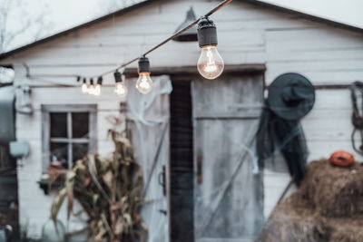 Illuminated light bulbs hanging on wall of building