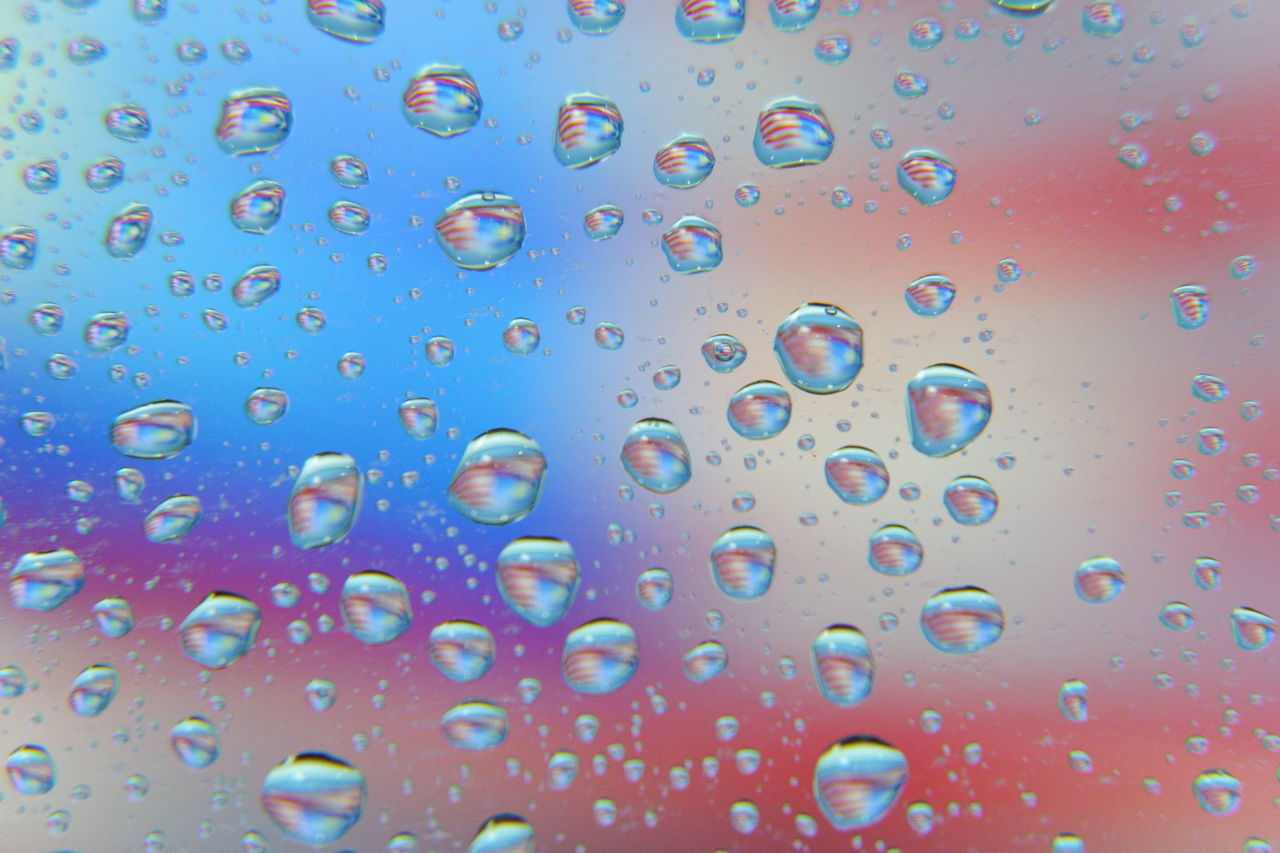 FULL FRAME SHOT OF WET GLASS WINDOW IN RAINY SEASON