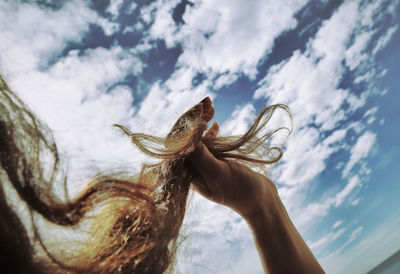 Close-up human hair against clouds