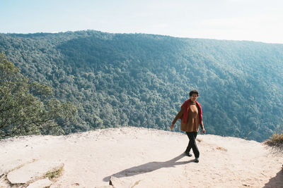 Rear view of man standing on landscape against sky