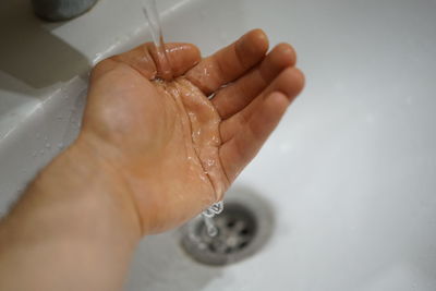 Close-up of hand on wet sand