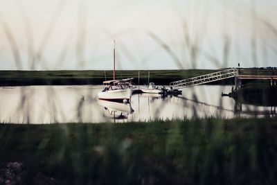 Boats moored in lake against sky