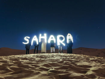 Man in sand against clear sky at night